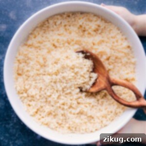 A bowl of fluffy cooked bulgur wheat, garnished with fresh herbs.