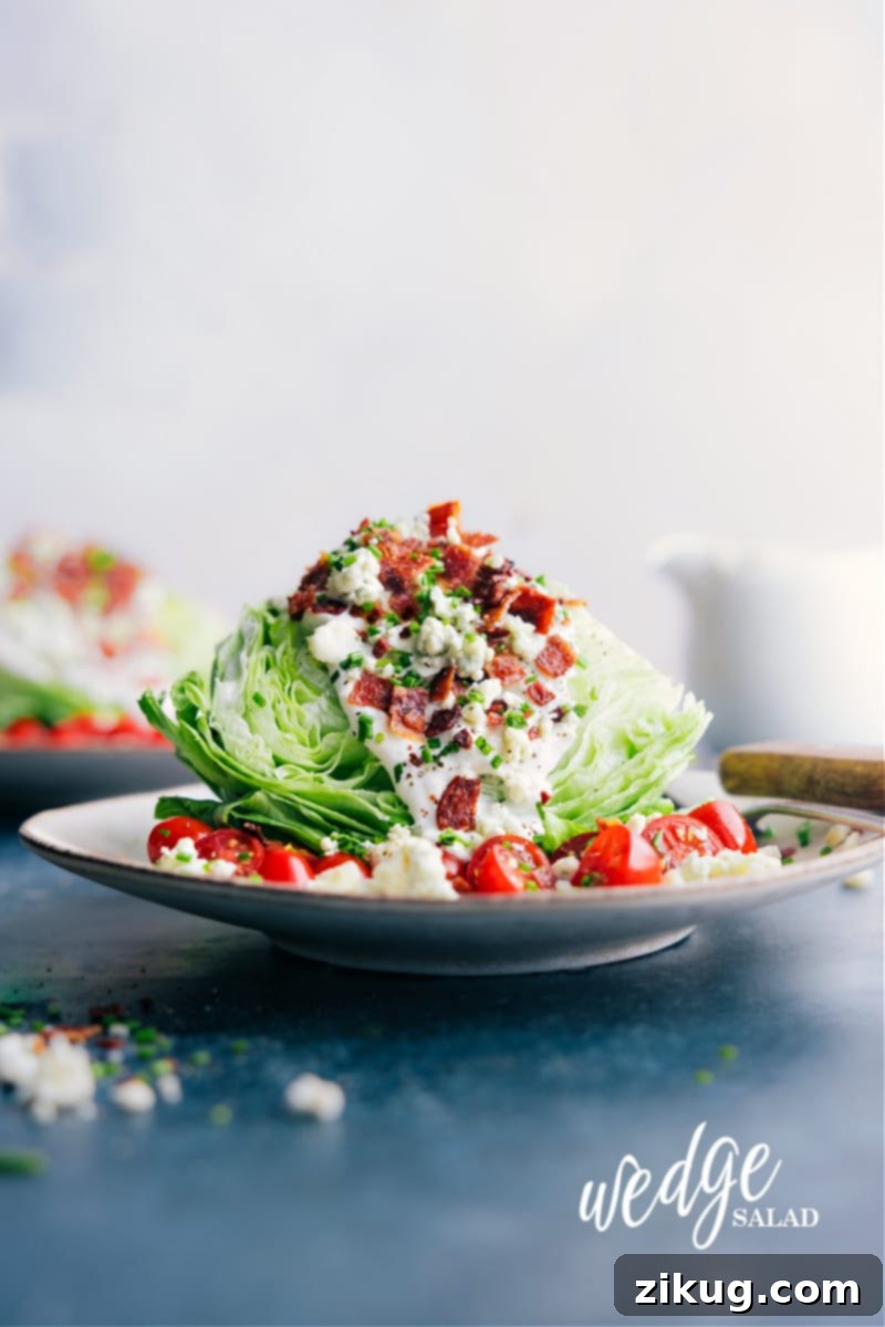 Introducing the ultimate Wedge Salad with the most amazing homemade blue cheese dressing! This classic, crunchy salad is the perfect combination of crisp iceberg lettuce, juicy cherry tomatoes, smoky bacon bits, and topped off with the best homemade blue cheese dressing. This dish is a crowd-pleaser and always a hit at dinner parties and special events. Recipe via chelseasmessyapron #sidedish #best #quick #easy #simple #familyfriendly #kidfriendly #wedgesalad Image of the Wedge Salad ready to be enjoyed