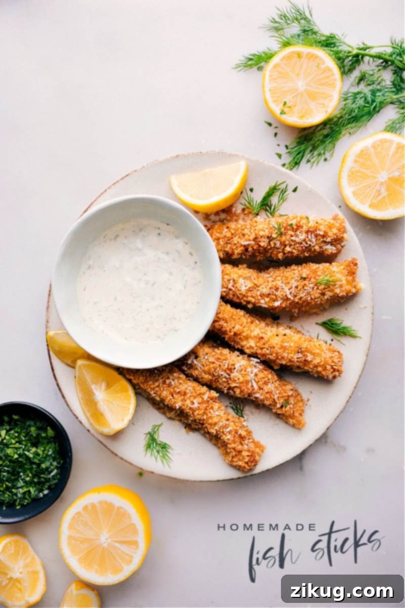 Gourmet Homemade Fish Sticks: Fresh Cod & Crispy Panko Overhead image of crispy homemade fish sticks with lemon wedges and tartar sauce.