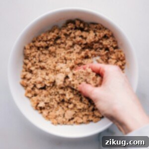 Kneading streusel mixture with fingers to form perfect crumbs