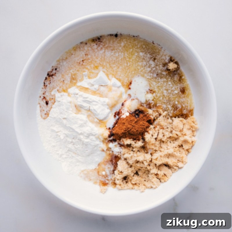 Process shots of how to make streusel, showing melted butter being poured into the dry ingredients for a smooth mixture