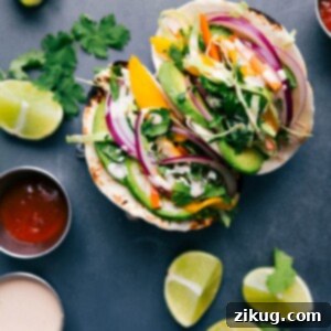 Firecracker Chicken Tacos 2 Asian chicken tacos stuffed with chicken, vegetables, and a complementary sauce, ready to be enjoyed.