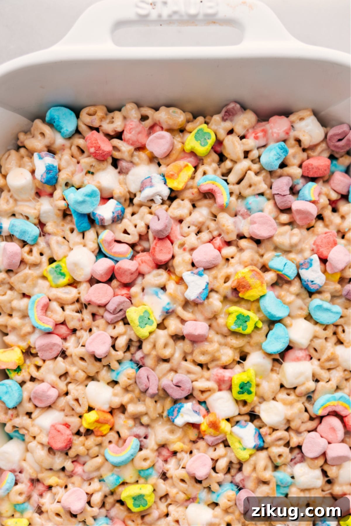 Perfectly set Lucky Charms Bars in a pan, ready to be cut into squares, served, and savored. Ideal for St. Patrick's Day.