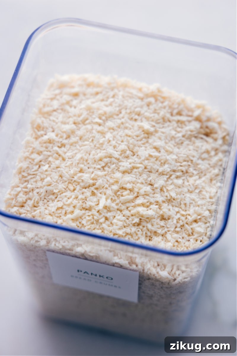 Overhead view of a clear container filled with coarse, light-colored panko breadcrumbs