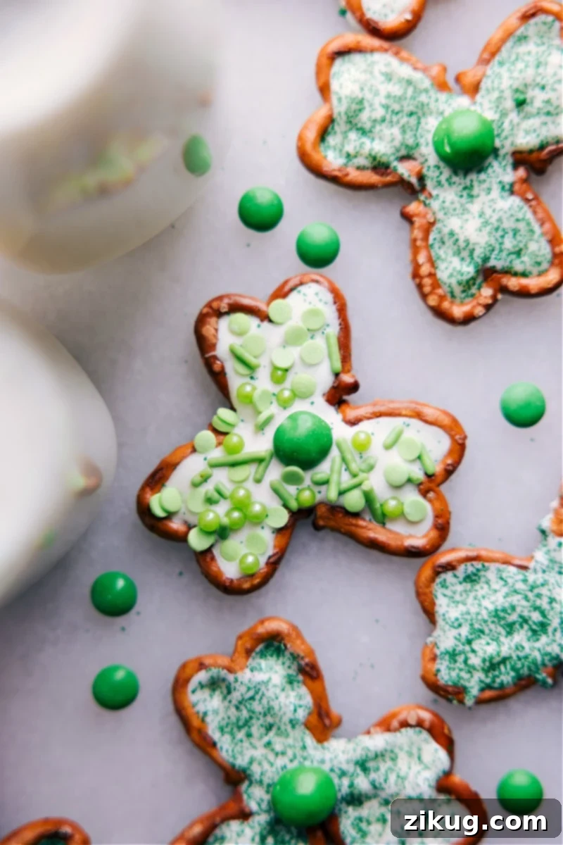 Transform a few simple ingredients into some downright delicious Pretzel Shamrocks -- perfect for St. Patrick's Day! Whether you're looking for a fun activity to do with the kids or a last-minute party snack, these Pretzel Shamrocks are the perfect thing to make! Close-up overhead view of a single Pretzel Shamrock, showing detailed chocolate and sprinkle decoration.