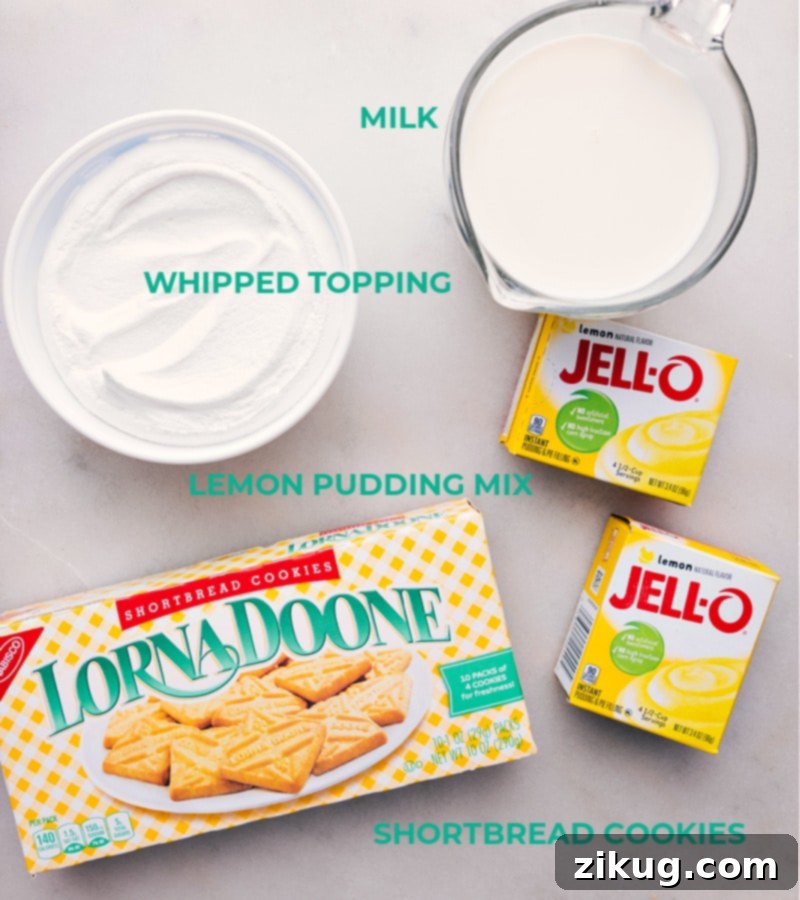 A collection of ingredients for Lemon Icebox Cake, including packages of shortbread cookies, lemon pudding mix, milk, and whipped topping, laid out on a clean surface.
