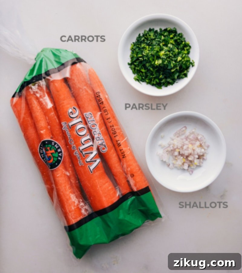 Key ingredients for French Carrot Salad: fresh carrots, shallots, parsley, and the components for the lemon-honey-Dijon dressing. Close-up image of the fresh ingredients for French Carrot Salad including carrots, shallots, parsley, lemons, olive oil, Dijon mustard, and honey.