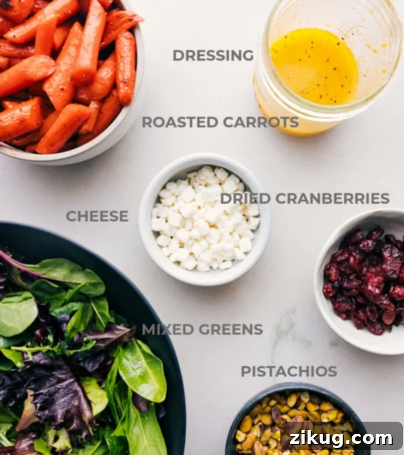 Ingredients In Carrot Salad A selection of fresh ingredients for the roasted carrot salad, including mixed greens, pistachios, cranberries, and goat cheese, neatly prepped and laid out for easy assembly.