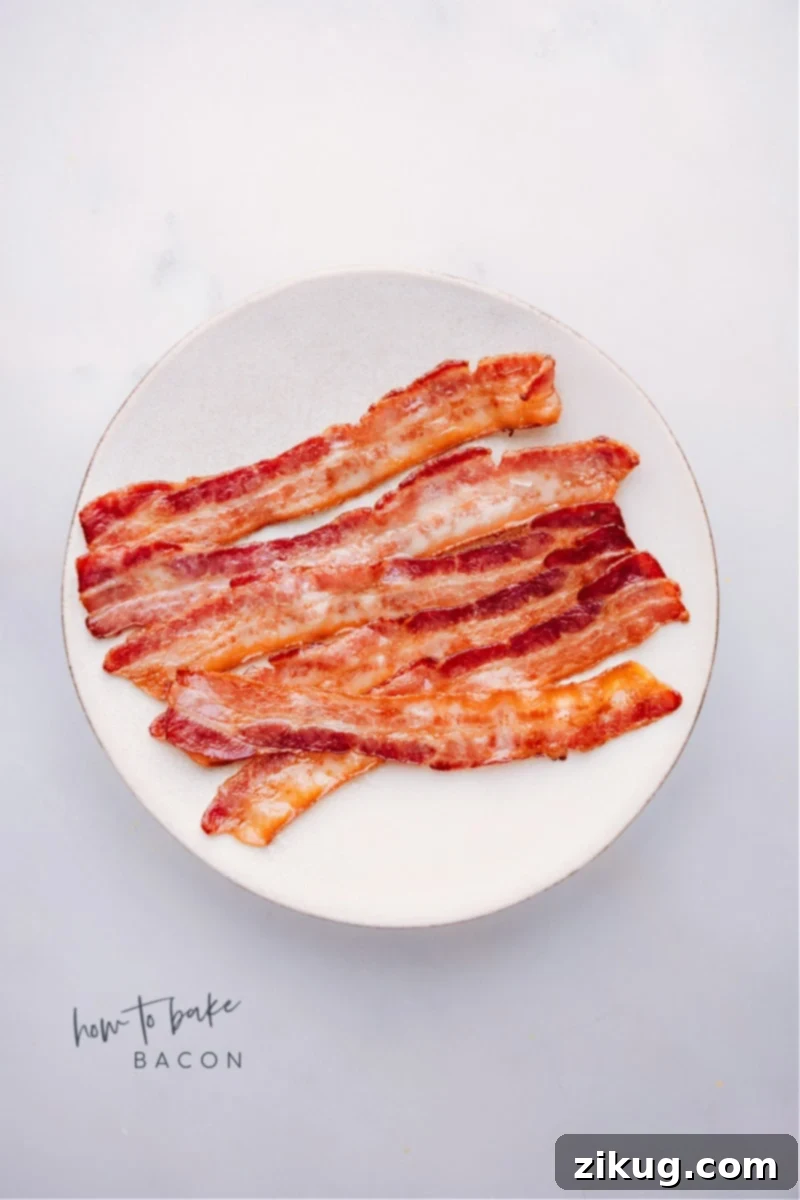 Overhead shot of perfectly baked crispy bacon strips on a cooling rack over a baking sheet.