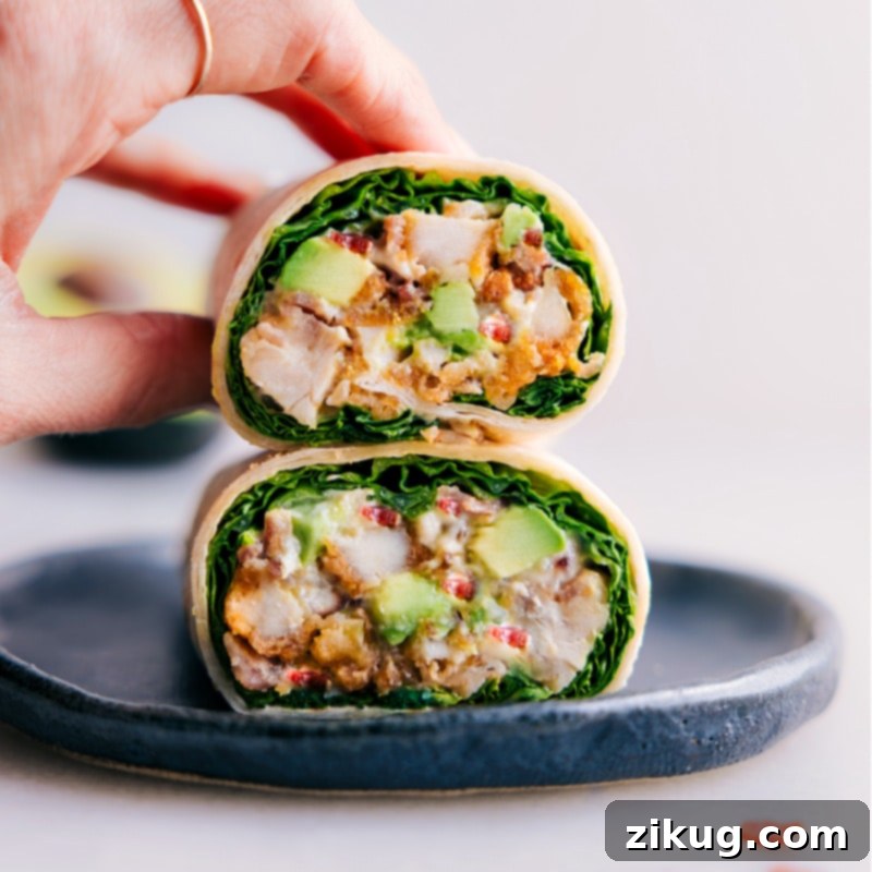 Image of a Chicken Bacon Avocado Wrap cut in half, stacked to show the vibrant layers inside