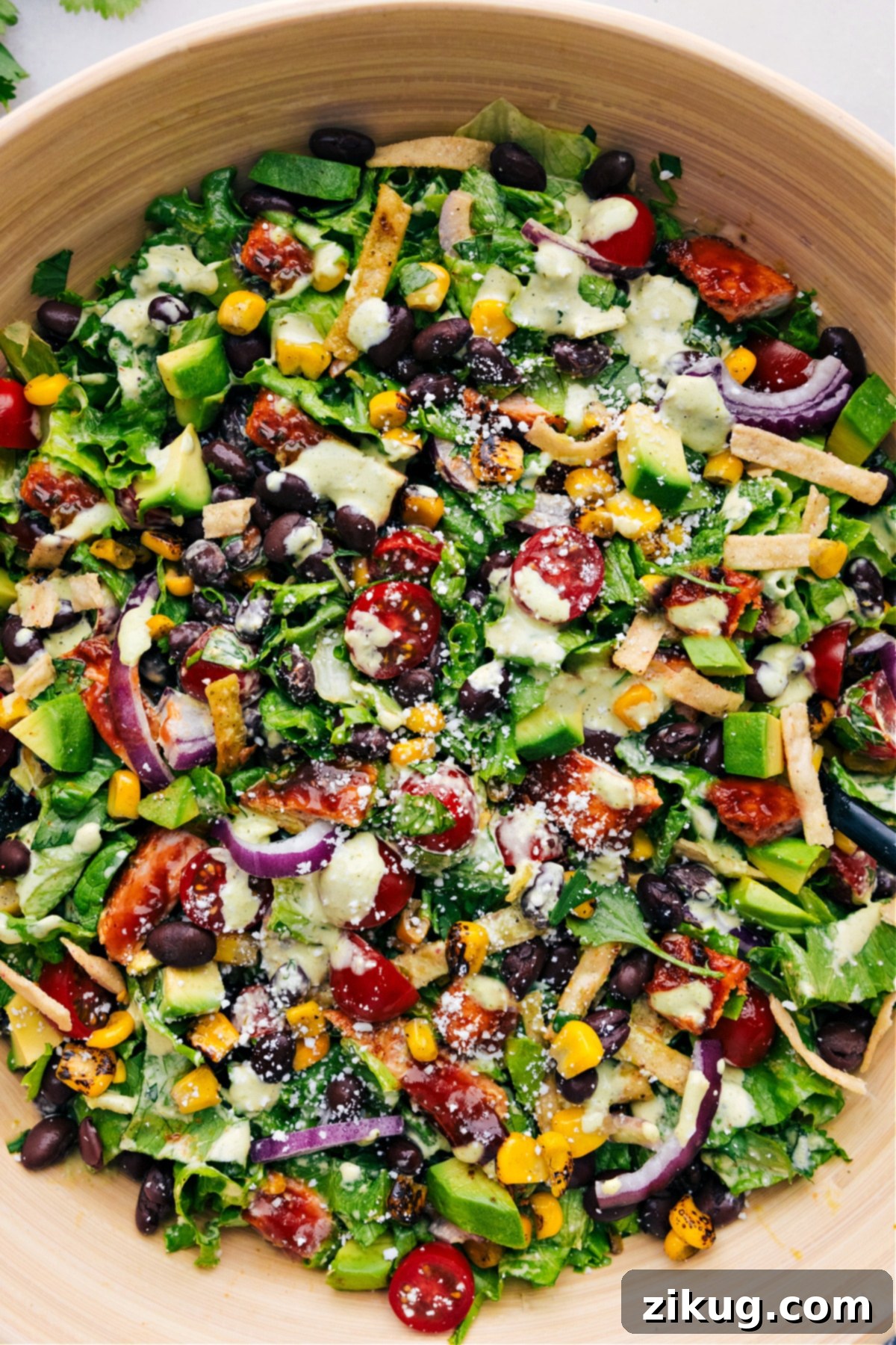 The Best BBQ Chicken Salad With Smoky Chicken And A Cilantro-Lime Dressing A beautifully presented BBQ Chicken Salad in a large bowl, showcasing smoky chicken, colorful vegetables, and a creamy dressing.