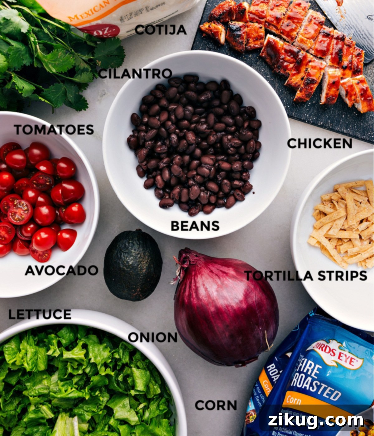 Ingredients Assembled To Make This Delicious Dish. A vibrant display of all the fresh ingredients required for the BBQ Chicken Salad, including grilled chicken, black beans, corn, avocado, tomatoes, lettuce, and red onion, alongside cheese and tortilla strips.