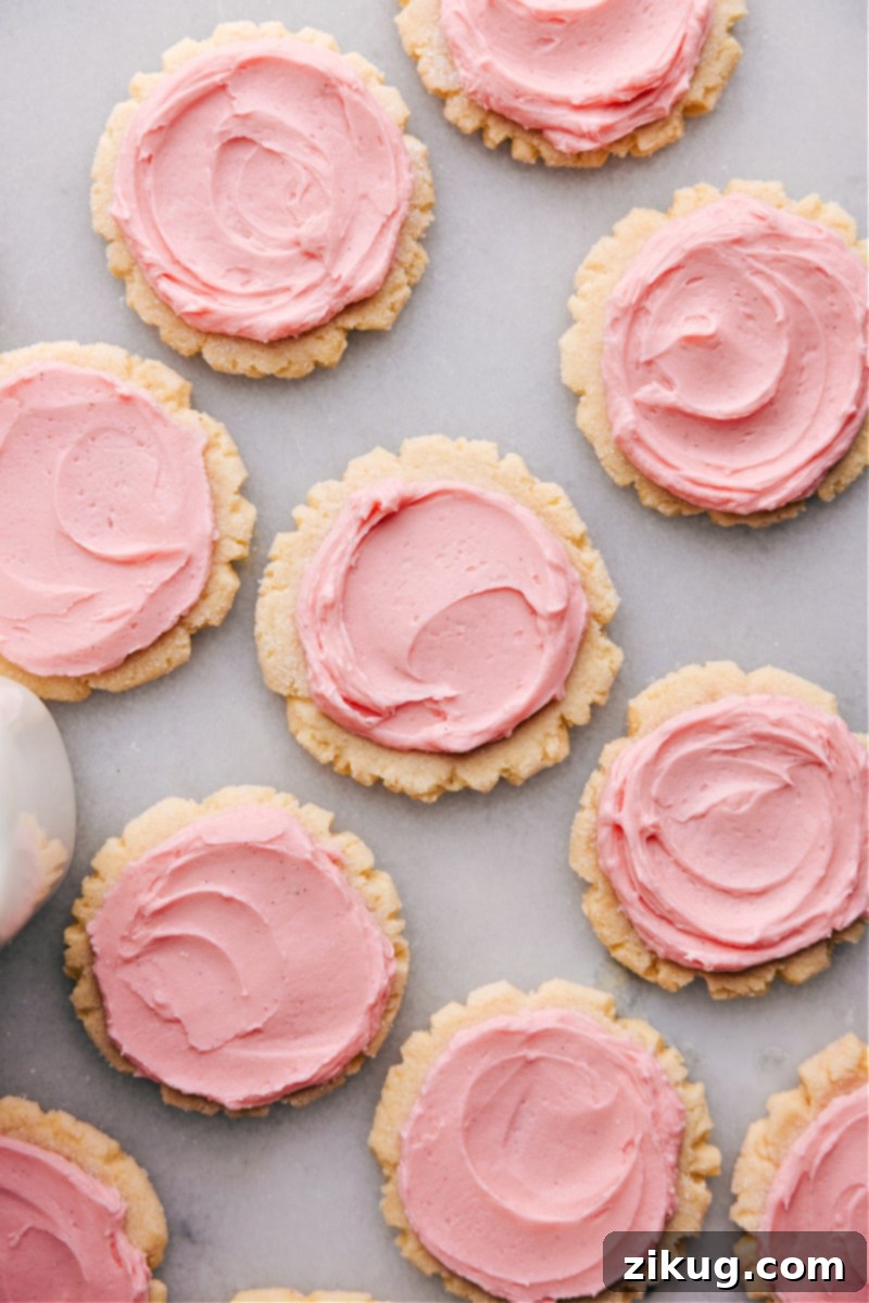 Batch of Delicious Swig Sugar Cookies with Thick Frosting An inviting overhead photograph of a large batch of freshly baked Swig Sugar Cookies, each expertly frosted with a thick, smooth layer, beautifully arranged and ready for enjoyment.
