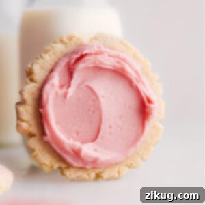 Close-up of a generously frosted Swig Sugar Cookie, highlighting its soft texture and the vibrant pink buttercream. It's an inviting visual of a delicious dessert.