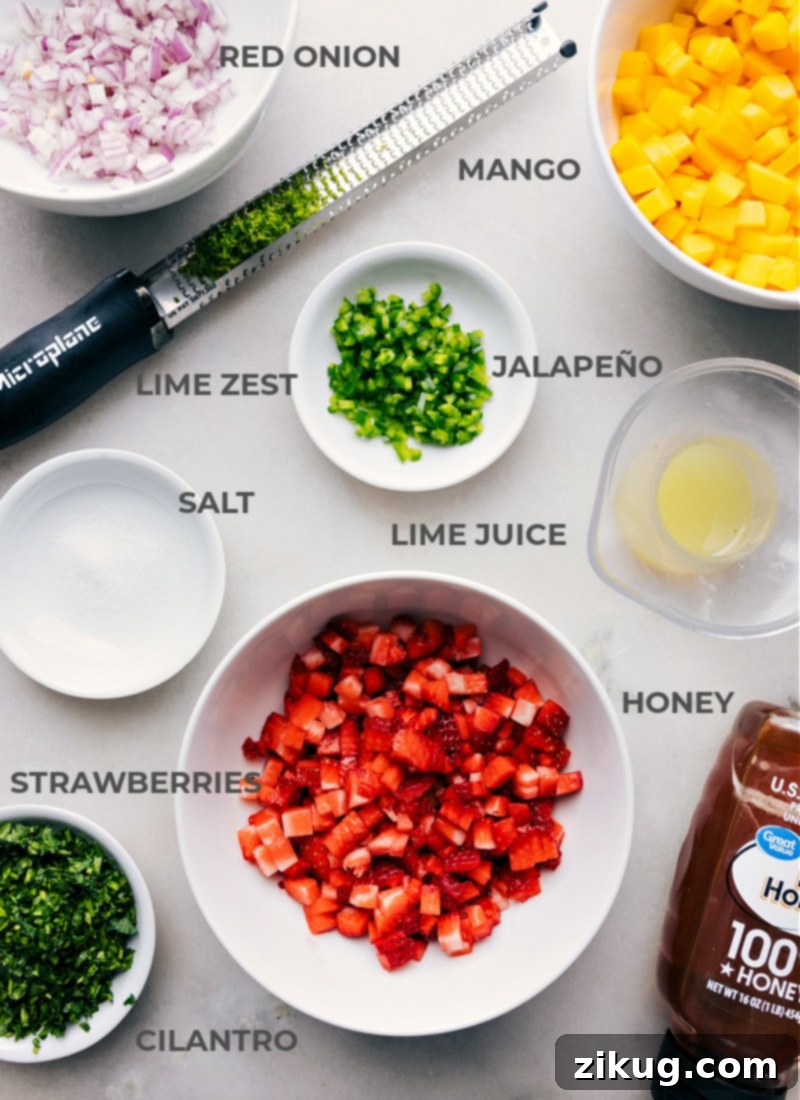 Ingredients In Strawberry Mango Salsa All the meticulously prepped ingredients for strawberry mango salsa laid out: vibrant red diced strawberries, golden cubed mango, finely minced red onion, bright green cilantro, a sliced lime, golden honey, and a pinch of salt.