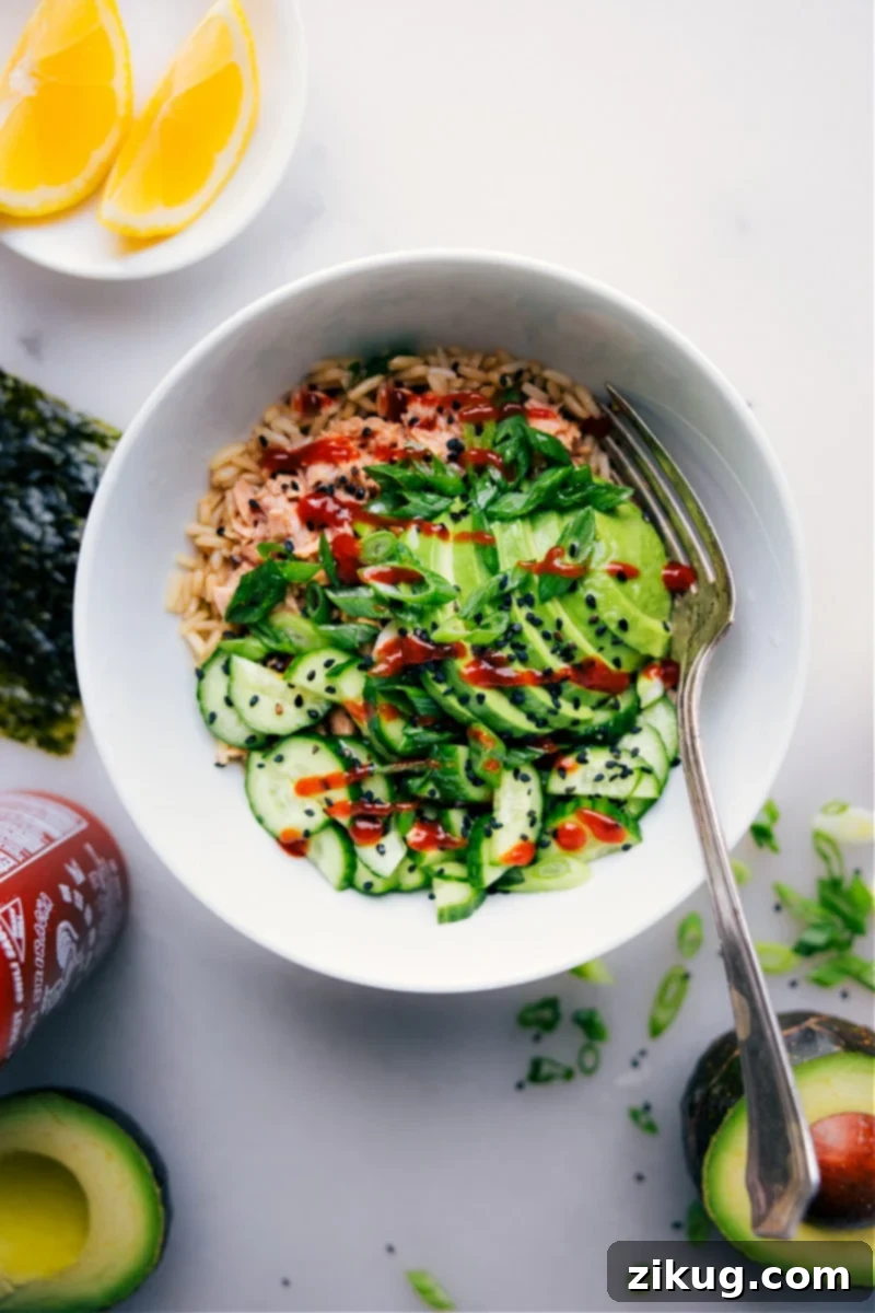 Instant Tuna Rice Delight 2 Overhead image of a beautifully arranged Tuna Rice Bowl, featuring creamy spicy tuna over rice, with fresh avocado, cucumber, green onions, and a lemon wedge, garnished with black sesame seeds.