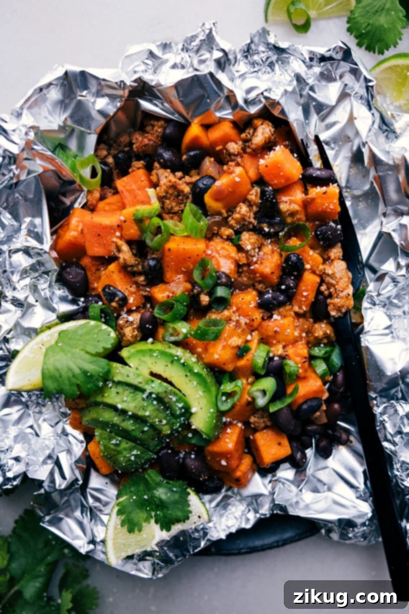 Savor the mouth-watering blend of sweet potatoes and taco-seasoned meat in these easy-to-prepare Taco Sweet Potato Foil Packets. Cooked to perfection either in the oven or on the grill, this delicious and wholesome meal is perfect for busy weeknights or relaxed weekends. Recipe via chelseasmessyapron #dinner #quick #easy #simple #familyfriendly #kidfriendly #healthy #lowcarb taco #sweetpotato #foilpackets Freshly cooked Sweet Potato Taco Foil Packets, glistening with cheese and ready to be served from the grill.
