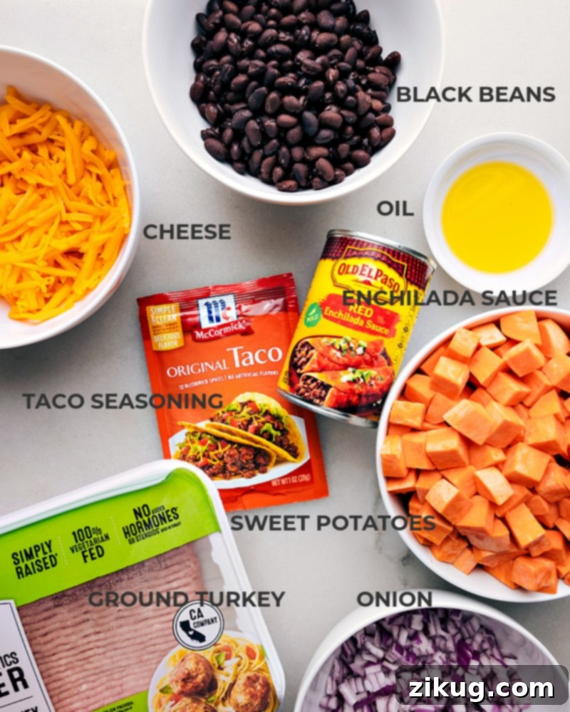 Savor the mouth-watering blend of sweet potatoes and taco-seasoned meat in these easy-to-prepare Taco Sweet Potato Foil Packets. Recipe via chelseasmessyapron #dinner #quick #easy #simple #familyfriendly #kidfriendly #healthy #lowcarb taco #sweetpotato #foilpackets A vibrant flat lay of all fresh ingredients required for the Sweet Potato Taco Foil Packets, including sweet potatoes, ground turkey, taco seasoning, red onion, black beans, and cheese.