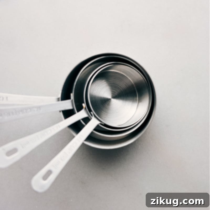 A collection of essential kitchen measuring tools including dry and liquid measuring cups, and measuring spoons.