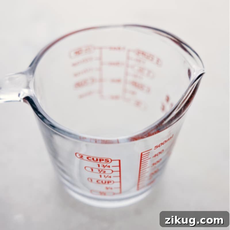 Clear liquid measuring cup on a kitchen counter, highlighting the accuracy needed for liquid measurements.