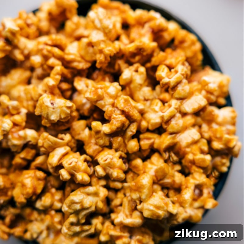 Make caramel corn the easiest way. Skip watching the stove for precise temperatures–instead, make this treat in the microwave oven! Quick and Easy Microwave Caramel Corn is a delicious shortcut that yields the salty-sweet treat we all crave! Recipe via chelseasmessyapron.com #dessert #quick #easy #simple #familyfriendly #movienight #treats #microwave #caramelcorn Up-close overhead image of the finished Microwave Caramel Corn, perfectly crunchy and appealing, served in a bowl.