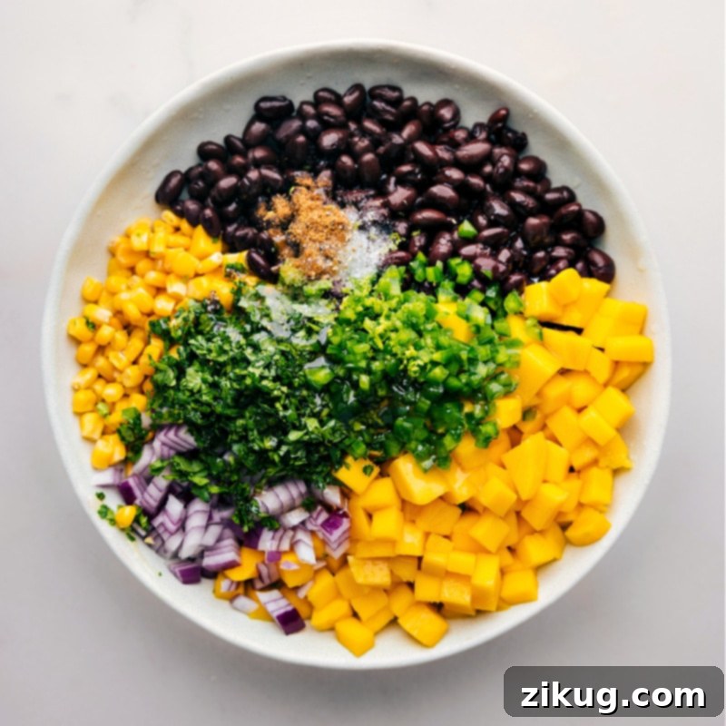 Mango Black Bean Salsa ingredients all added to a bowl to be mixed together.