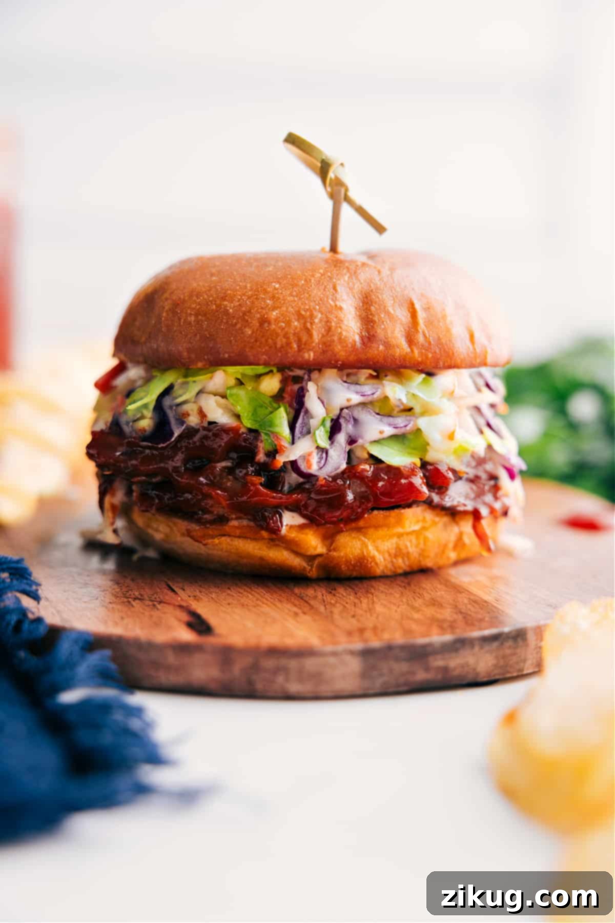 Ready-to-Eat Crockpot BBQ Pulled Pork Sandwich Stuffed with Flavorful Ingredients A perfectly assembled Pulled Pork Sandwich with tender BBQ pork, crisp coleslaw, and a toasted bun, presented on a rustic tray, ready to be enjoyed.