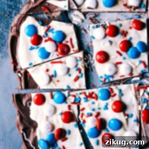 Firecracker Fourth of July Bark 3 A square image showing a finished piece of 4th of July Bark with layers of chocolate and festive toppings.