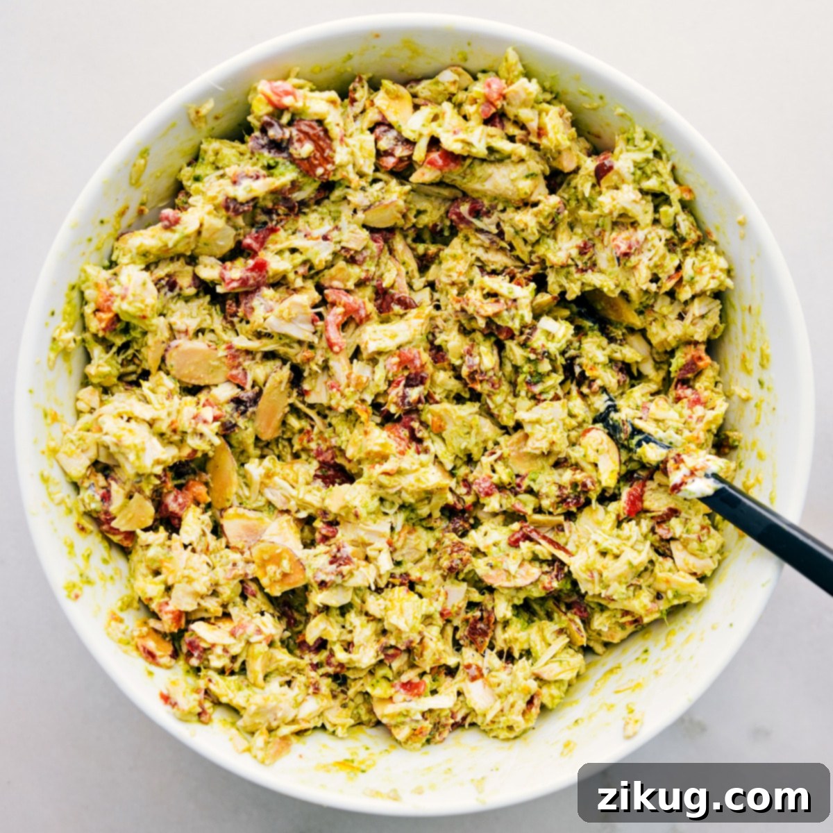 Perfectly Mixed Pesto Chicken Salad Pesto Chicken Salad, perfectly mixed and glistening with dressing, showcased in a large bowl, ready to be served.