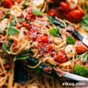 A vibrant bowl of Caprese Pasta with cherry tomatoes, basil, and mozzarella, ready to be served.