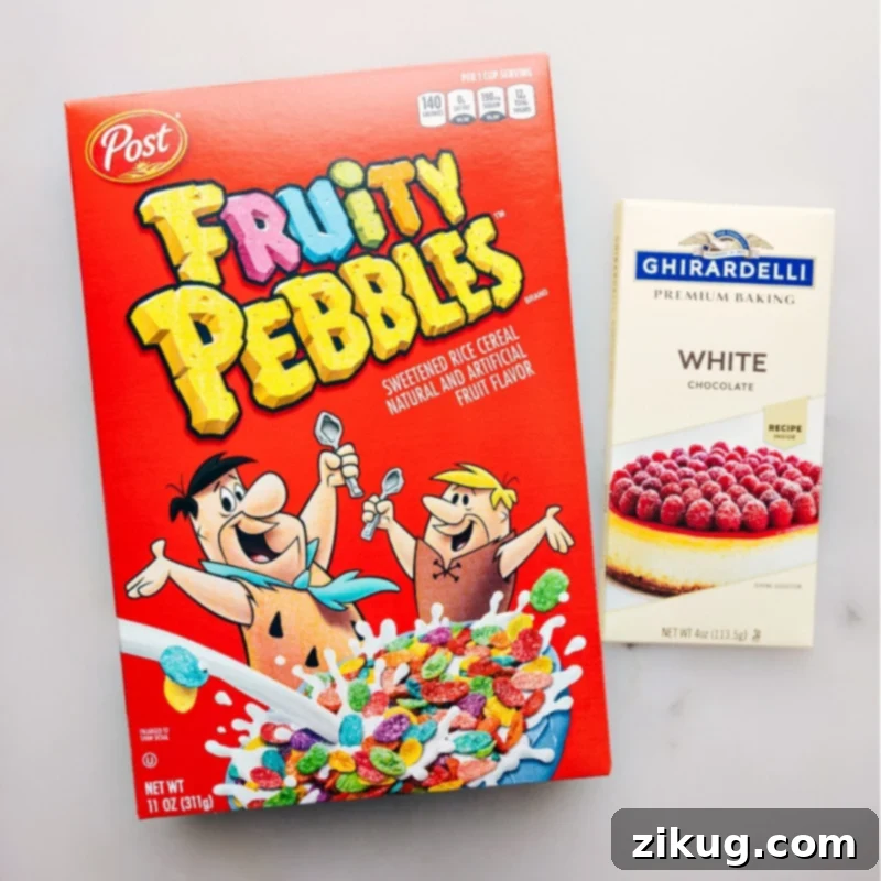 Close-up shot of all three ingredients for Fruity Pebble Crunch Candy: Fruity Pebbles cereal, a white chocolate bar, and a small container of coconut oil.