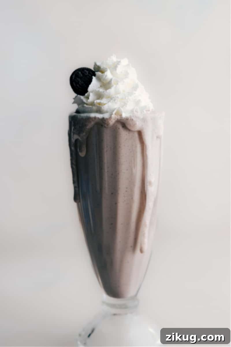 Oreo Milkshake Ready to Serve A delicious homemade Oreo milkshake garnished with whipped cream and crushed cookies, perfectly ready for enjoyment.