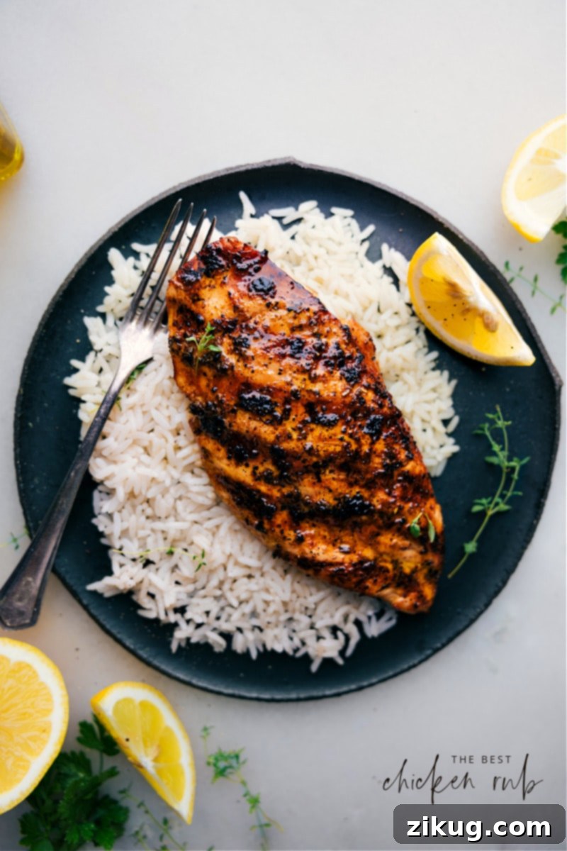 The Best Chicken Rub applied to grilled chicken, served on a bed of rice for a mouthwatering meal.