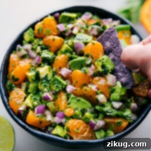 A bowl of fresh Avocado-Orange Salsa with a side of tortilla chips, ready for serving.