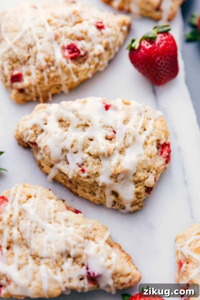 Freshly baked strawberry scones with a delicate sweet glaze on top, arranged beautifully on a cooling rack, ready to be enjoyed.