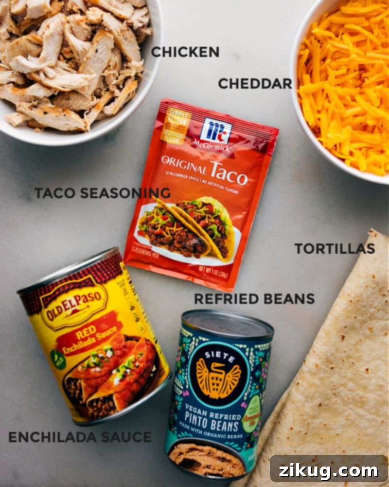 These Crispy Chicken Wraps deliver a delightful fusion of flavors with smoky, spiced shredded chicken and rich, creamy refried beans and melty cheddar cheese nestled inside a crispy, golden-brown tortilla. A quick, easy, and simple recipe that is family-friendly and kid-friendly, perfect for dinner or lunch. #dinner #quick #easy #simple #familyfriendly #kidfriendly #lunch #crispy #chicken #wraps A vibrant ingredient shot showing all components needed for Crispy Chicken Wraps, neatly arranged.