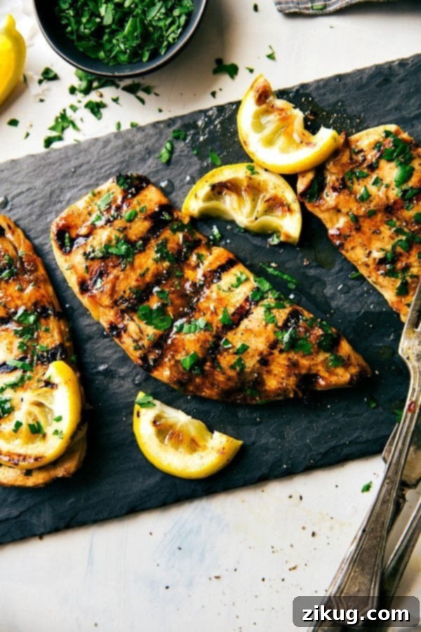 Grilled chicken covered in flavorful chicken marinade and topped with fresh herbs, perfectly cooked and full of flavor.