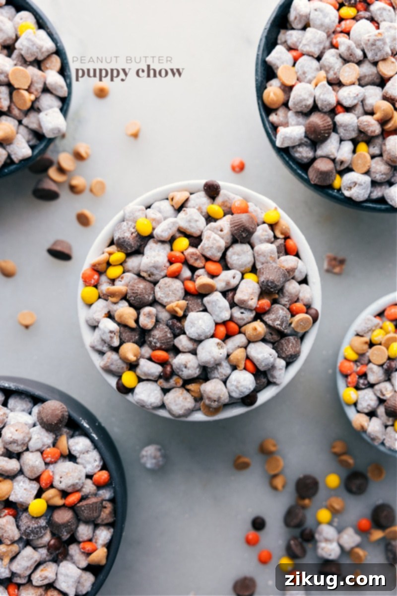 Irresistible Peanut Butter Puppy Chow: Crunchy Cereal, Sweet Chocolate, and Powdered Sugar Perfection with Reese's and Peanut Butter Chips. Overhead image of the Peanut Butter Puppy Chow, showcasing its delicious texture and powdered sugar coating