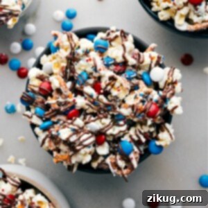Close-up of 4th of July popcorn in a bowl, showing the white chocolate, pretzels, and M&Ms.