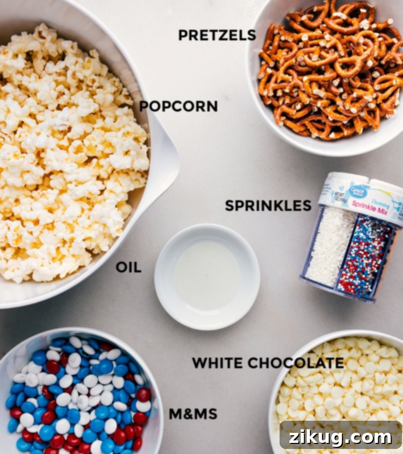 All the ingredients for 4th of July Popcorn laid out, including popcorn, pretzels, sprinkles, white chocolate, and M&Ms, ready for easy assembly.