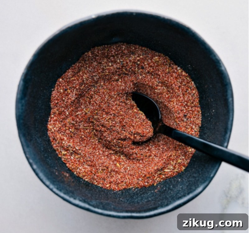 This Blackening Seasoning recipe is an easily homemade, versatile, smoky, and spicy blend of everyday spices, perfect for forming a flavorful crust on grilled or pan-fried dishes. A pristine white bowl filled with the perfectly combined blackened seasoning, showing its rich, earthy color and fine texture, ready to be used or stored.