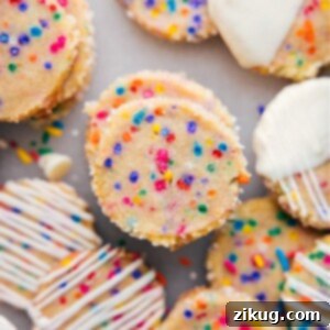 Plate of freshly baked slice and bake cookies, some with white chocolate drizzle.