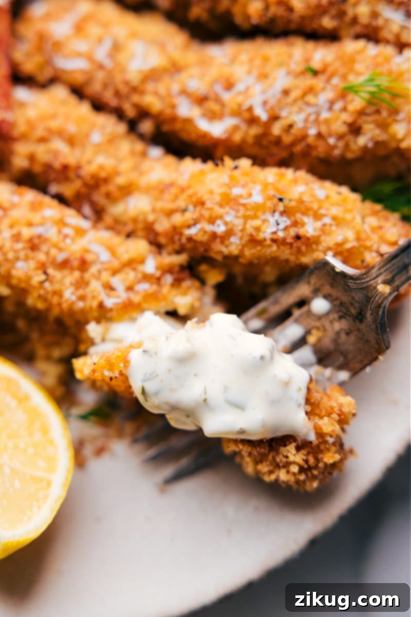 Deliciously healthy and crispy Baked Fish and Chips ready to eat. Up close overhead image of the finished Baked Fish and Chips, served on a platter with lemon wedges