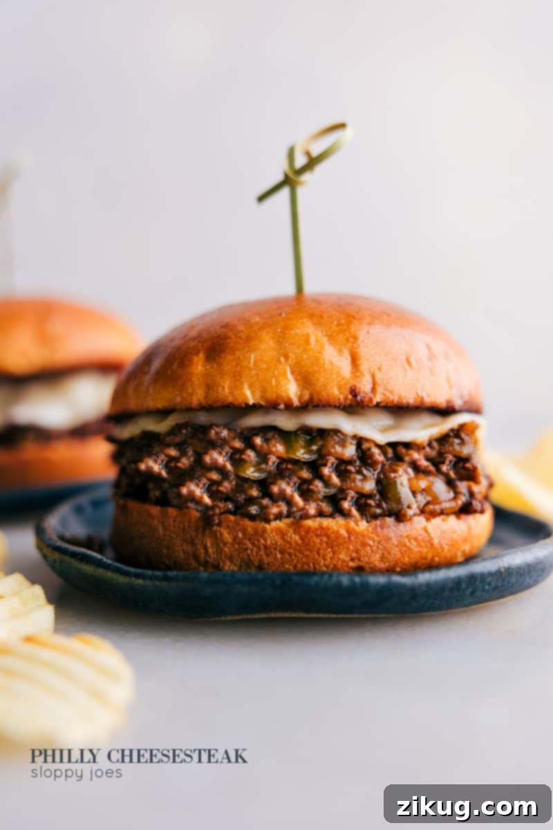 Philly Cheesesteak Sloppy Joes: Ground beef, A1 sauce, Worcestershire, ketchup, provolone, toasted brioche bun. A quick and easy family dinner mash-up! Delicious Philly Cheesesteak Sloppy Joes served on toasted brioche buns, oozing with melted cheese and savory ground beef, garnished with fresh herbs.