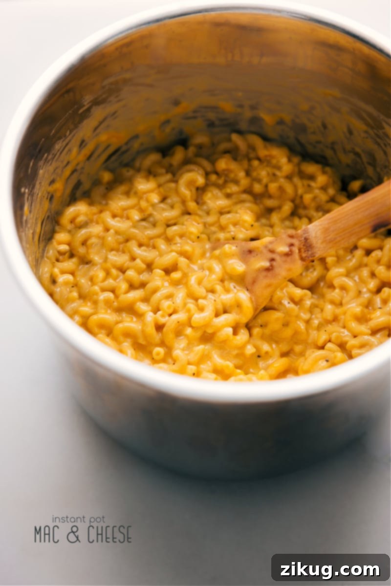 Overhead shot of a steaming bowl of creamy Instant Pot Mac and Cheese, garnished with fresh parsley.