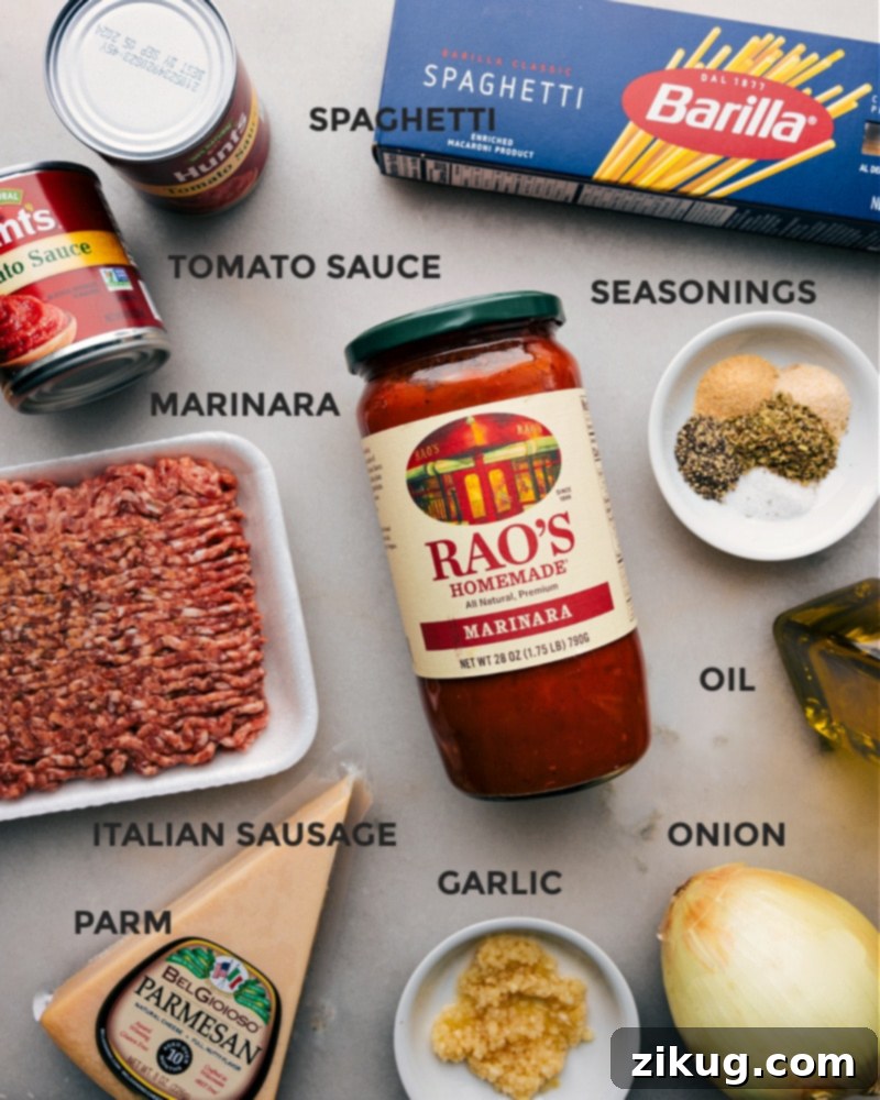 High-quality ingredients are key for delicious Instant Pot Spaghetti. A flat lay image displaying all the fresh ingredients for Instant Pot Spaghetti, including ground Italian sausage, marinara, pasta, onions, garlic, and seasonings.