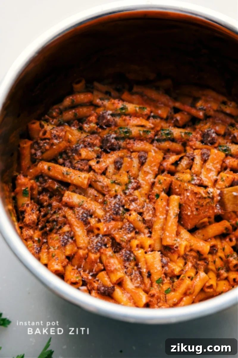 Instant Pot Baked Ziti: A creamy, flavor-packed pasta dish with robust Italian sausage and rich Parmesan tomato sauce. An effortless weeknight win in your trusty pressure cooker! Overhead image of the Instant Pot Baked Ziti, still in the pot, showcasing its cheesy, saucy texture