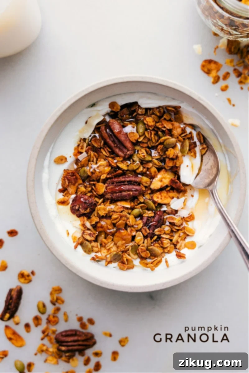 Overhead image of freshly baked Pumpkin Granola scattered on a baking sheet, showcasing its golden-brown clusters, nuts, and seeds.