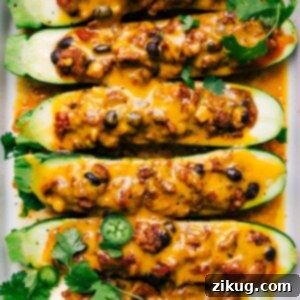 Finished mexican zucchini boats with melted cheese and fresh herbs on top, a hearty and healthy meal.