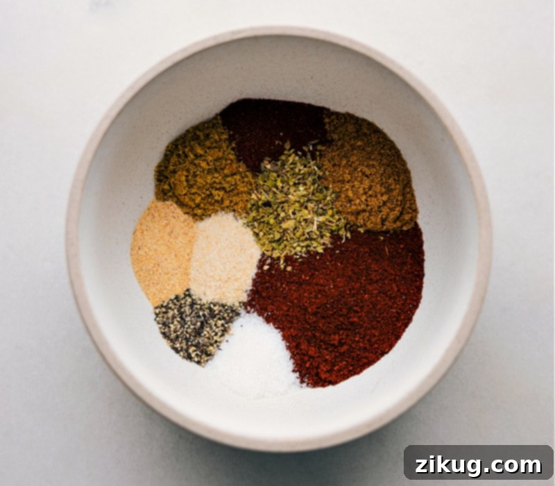 Key Spices for Savory Pumpkin Chili Assortment of chili spices laid out: chili powder, cumin, oregano, smoked paprika, salt, and pepper.